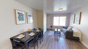 Dining space with a textured ceiling and wood finished floors