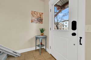 Entryway featuring light tile patterned floors and baseboards