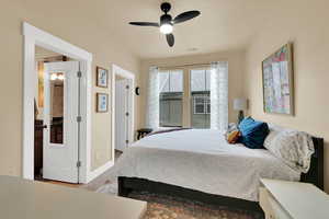 Carpeted bedroom featuring ceiling fan and baseboards
