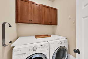 Laundry area featuring cabinet space and washing machine and dryer