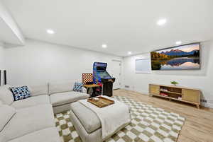 Living room with light wood finished floors and recessed lighting