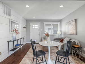 Dining room with dark wood-style flooring and recessed lighting