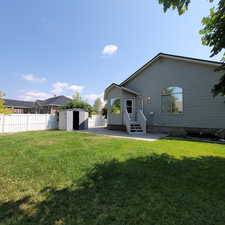 Back of house with a patio area, a fenced backyard, a storage unit, and entry steps