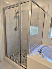 Full bath with a jetted tub and a stall shower
