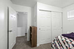 Bedroom featuring dark colored carpet and a closet