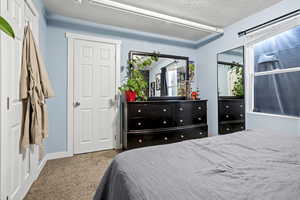 Bedroom with carpet and a textured ceiling