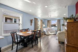 Dining area featuring recessed lighting, a textured ceiling, dark wood finished floors, and a fireplace