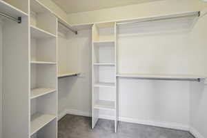 Walk in closet with dark colored carpet