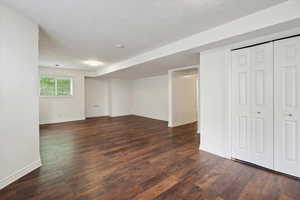 Basement with dark wood-style floors and a textured ceiling