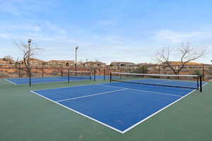 View of tennis court featuring a residential view and community basketball court