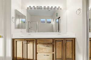 Full bathroom with double vanity and a shower stall