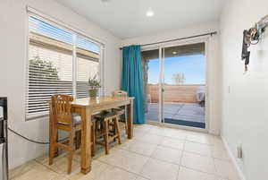 Dining room with light tile patterned floors and recessed lighting