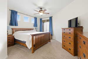 Bedroom with light carpet and a ceiling fan