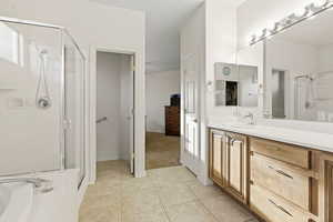 Bathroom featuring a stall shower, vanity, a bath, and light tile patterned floors