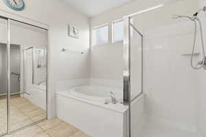 Bathroom with a stall shower, a bath, and light tile patterned floors
