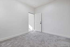 Carpeted spare room featuring baseboards