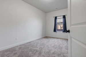 Spare room featuring light carpet and a textured ceiling