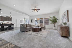 Living area featuring a chandelier, ceiling fan, recessed lighting, and lofted ceiling