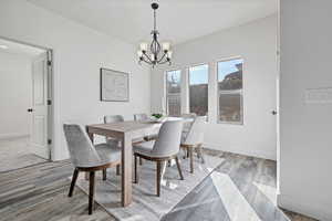 Dining area featuring light wood-type flooring and a chandelier