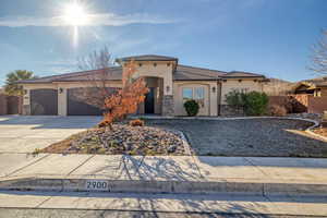 View of front of house with driveway, stucco siding, a garage, a tile roof, and stone siding