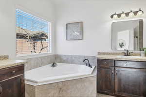 Bathroom featuring vanity and a bath