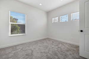 Carpeted empty room with baseboards and recessed lighting