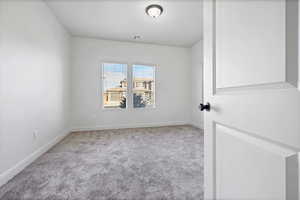 Empty room with light carpet and baseboards
