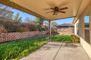 Fenced backyard with ceiling fan and a patio