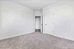 Unfurnished bedroom featuring carpet floors and baseboards