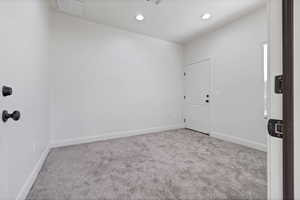 Carpeted empty room featuring baseboards and recessed lighting