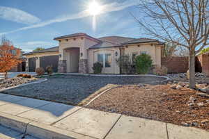 Mediterranean / spanish home featuring stucco siding, a garage, a tile roof, and stone siding