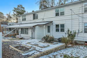 Rear view of house with a vegetable garden and a chimney
