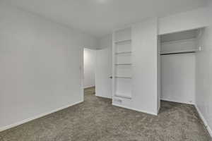 Unfurnished bedroom with light colored carpet and baseboards