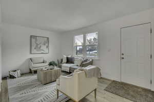 Living area featuring baseboards and light wood-type flooring
