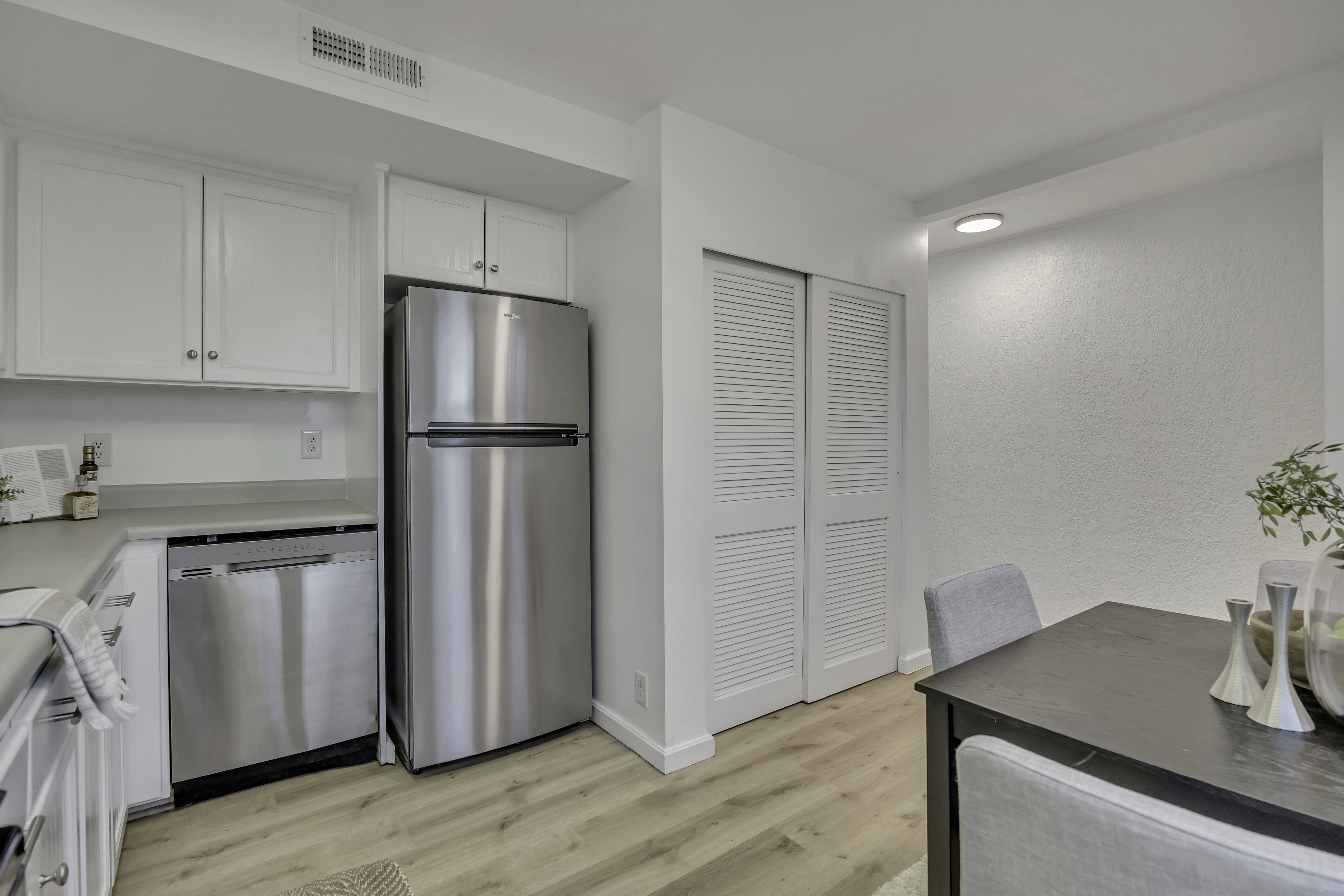 Kitchen featuring white cabinetry, appliances with stainless steel finishes, light countertops, and light wood finished floors