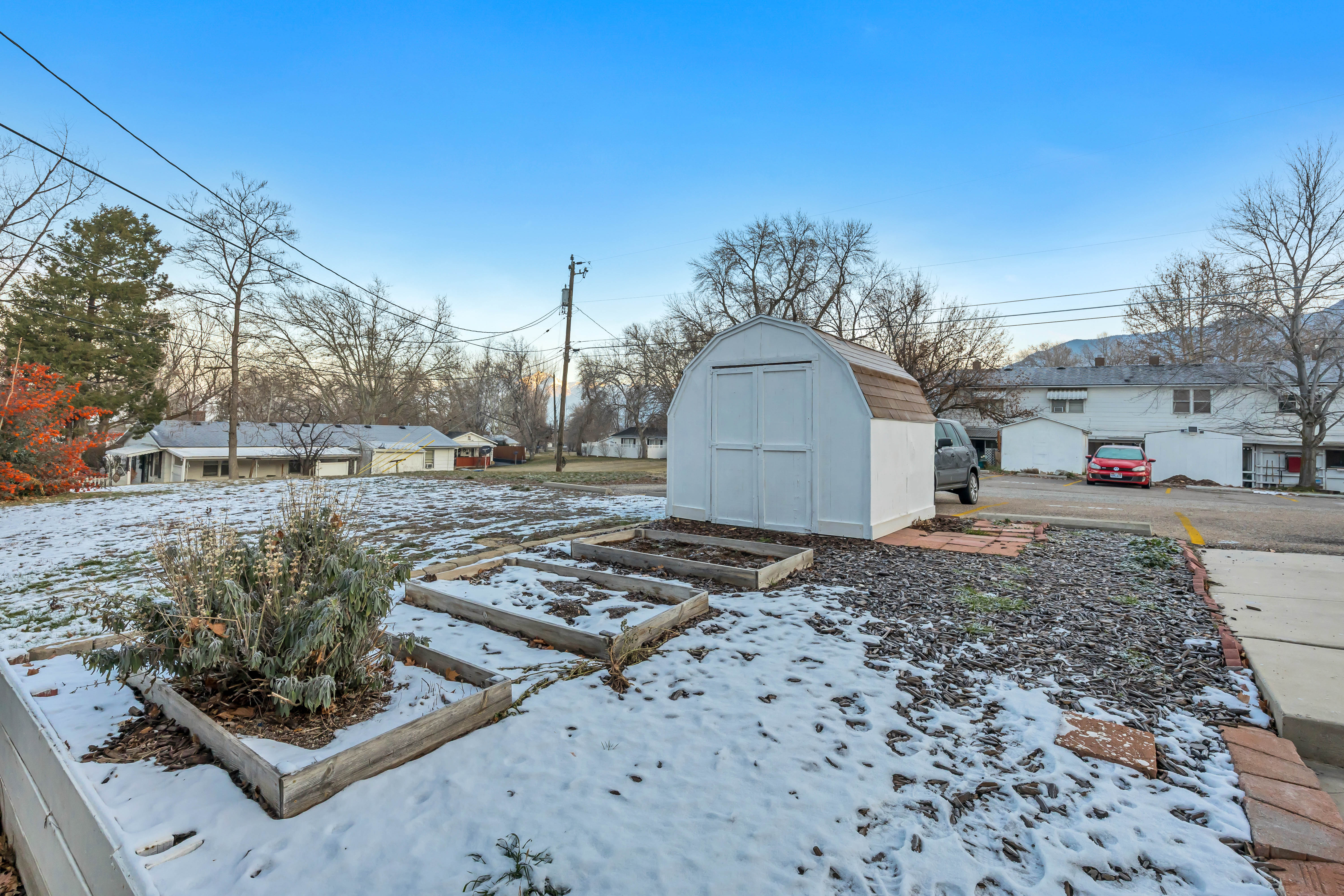 View of yard featuring a garden and a storage unit