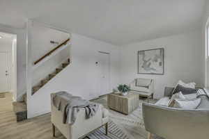 Living room with stairway and wood finished floors