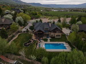 Aerial view of property and surrounding area with a pool and mountains