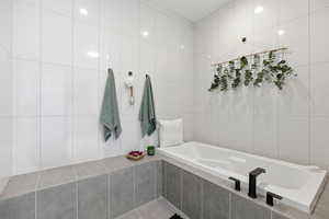 Bathroom featuring tile walls and a bath