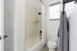 Full bath featuring shower / bath combination with curtain and light tile patterned floors