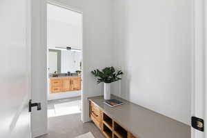 Corridor featuring light tile patterned flooring and a sink