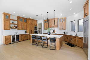 Kitchen with glass insert cabinets, a breakfast bar, open shelves, and an island with sink