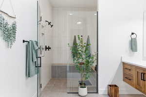 Bathroom featuring vanity, a shower stall, and light tile patterned floors