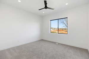 Empty room featuring light carpet, ceiling fan, and recessed lighting