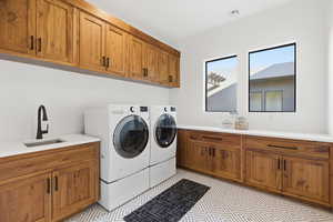 Laundry area featuring cabinet space, separate washer and dryer, and light flooring