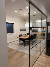 Home office with ornamental molding, light wood-type flooring, and recessed lighting