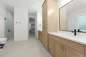 Full bath with vanity, a shower stall, light tile patterned floors, and a walk in closet
