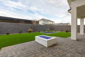 Fenced backyard with a patio area and a fire pit