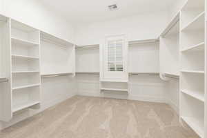 Walk in closet featuring light carpet