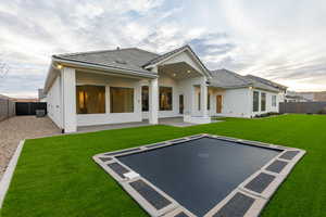 Rear view of property with a fenced backyard, a patio, stucco siding, a tiled roof, and uncovered parking